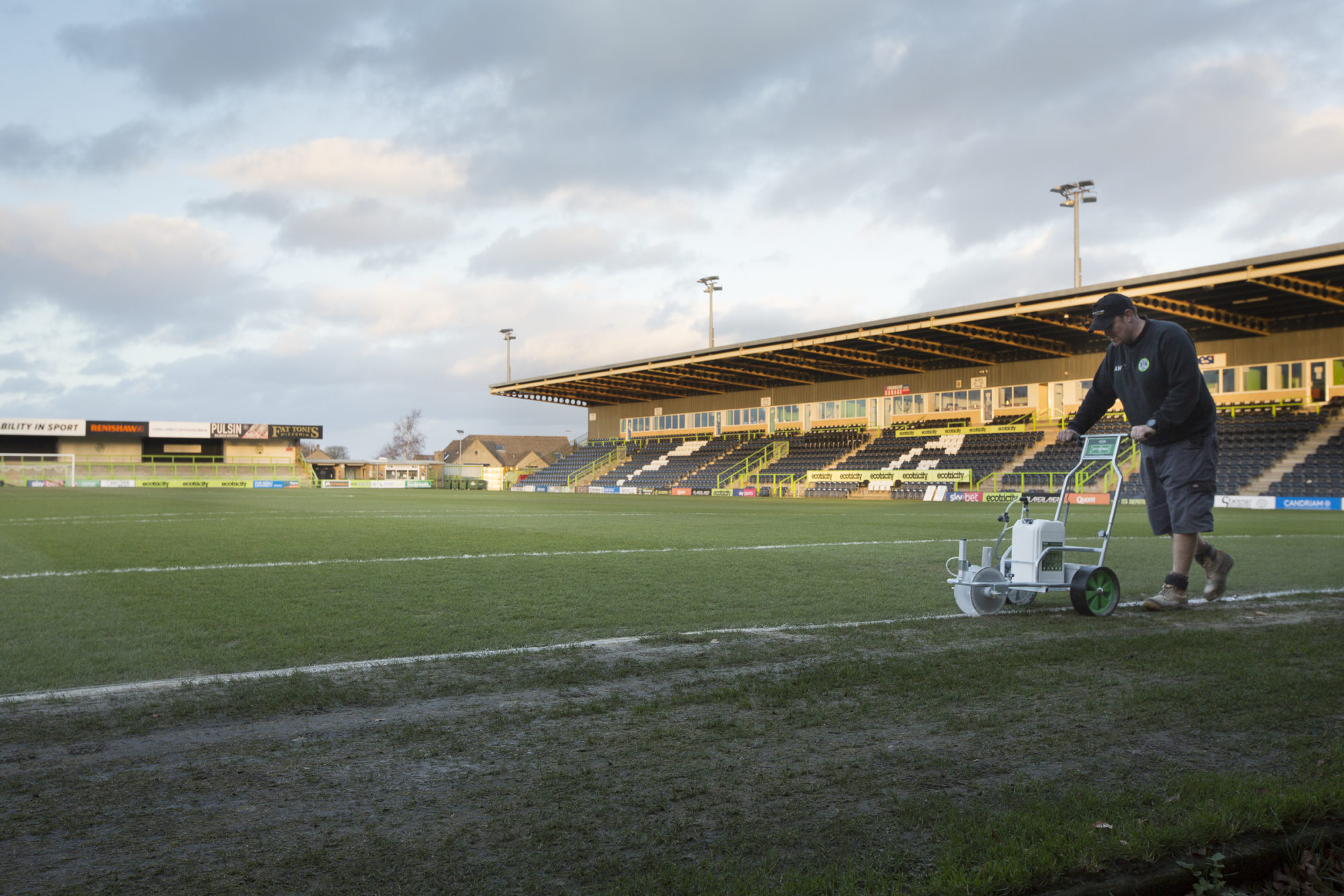 <p>Forest Green&#8217;s groundsman Adam Witchell marks the byline before a League Two match with Port Vale (image: Chris Davy/ China Dialogue)</p>