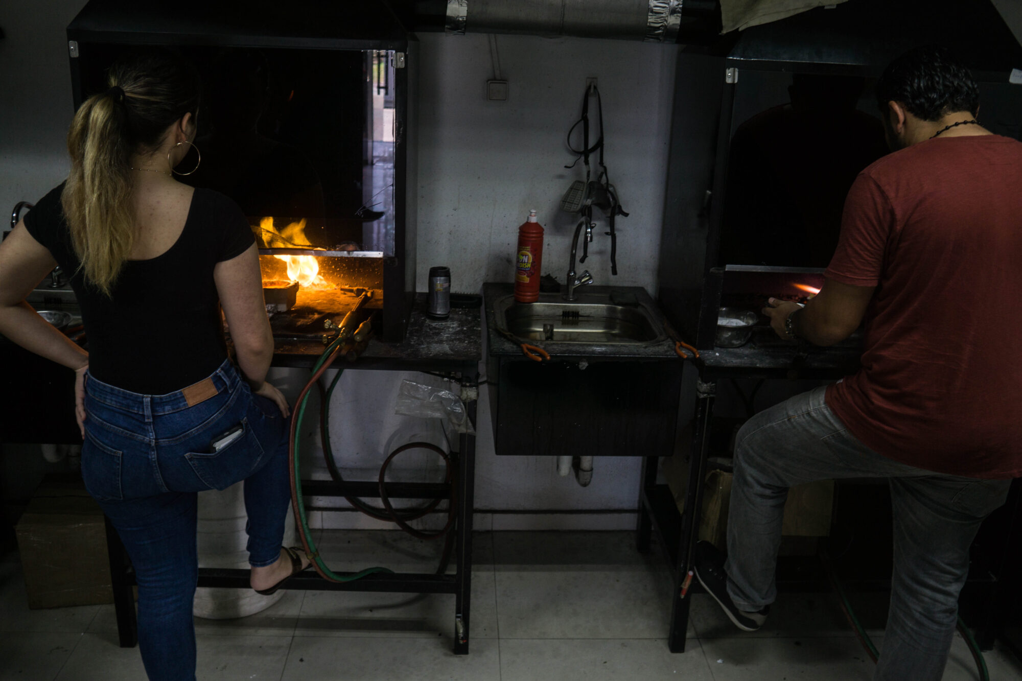 Two people burning gold at a shop in Suriname