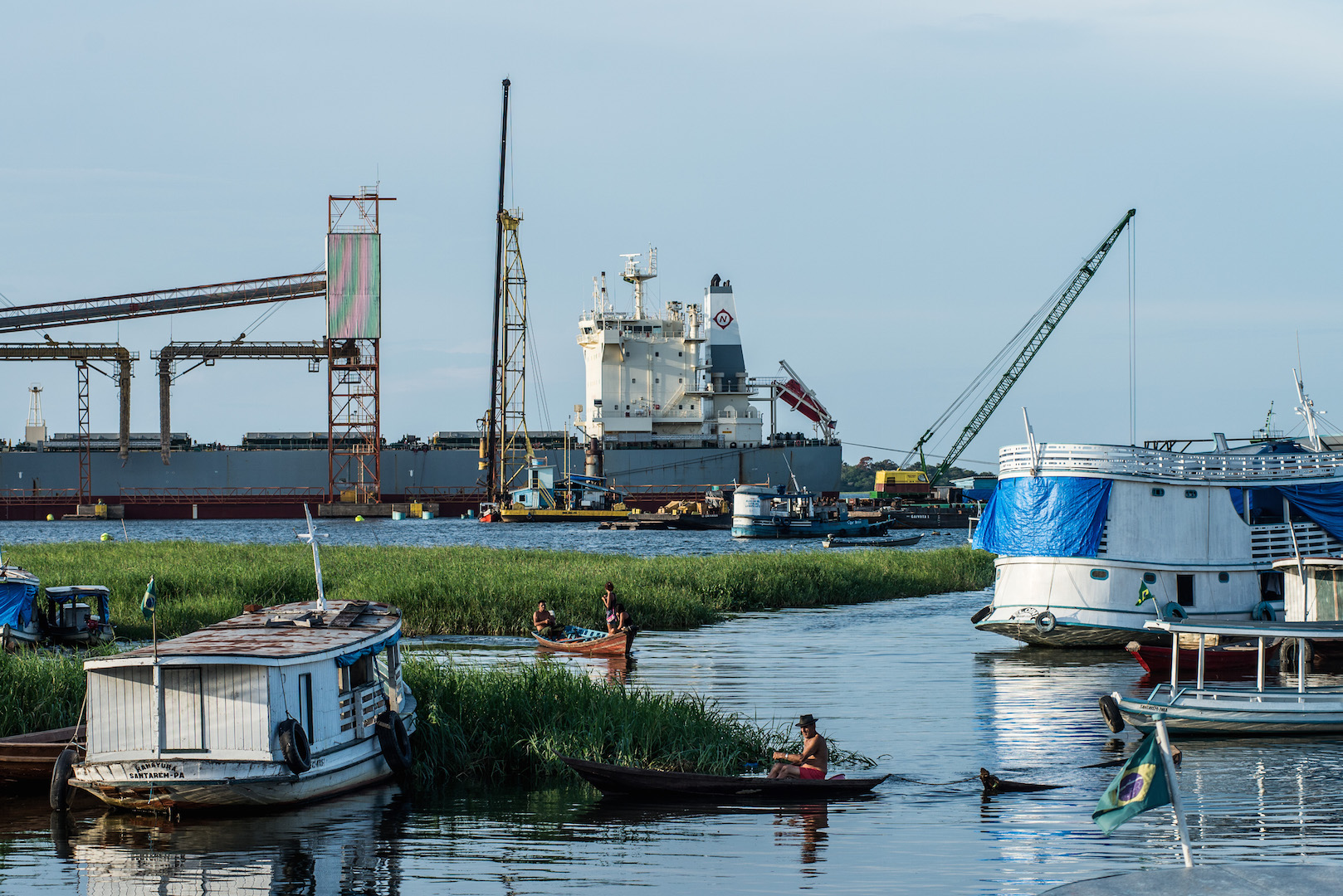 Riverine communities fish against the backdrop of Cargill's Santarem port 