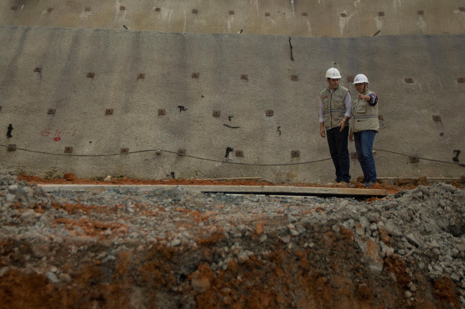 A Chinese and an Ecudorean engineer inspect work at the Chinese-financed Minas-San Francisco hydroelectric project in Sarayunga, Ecuador