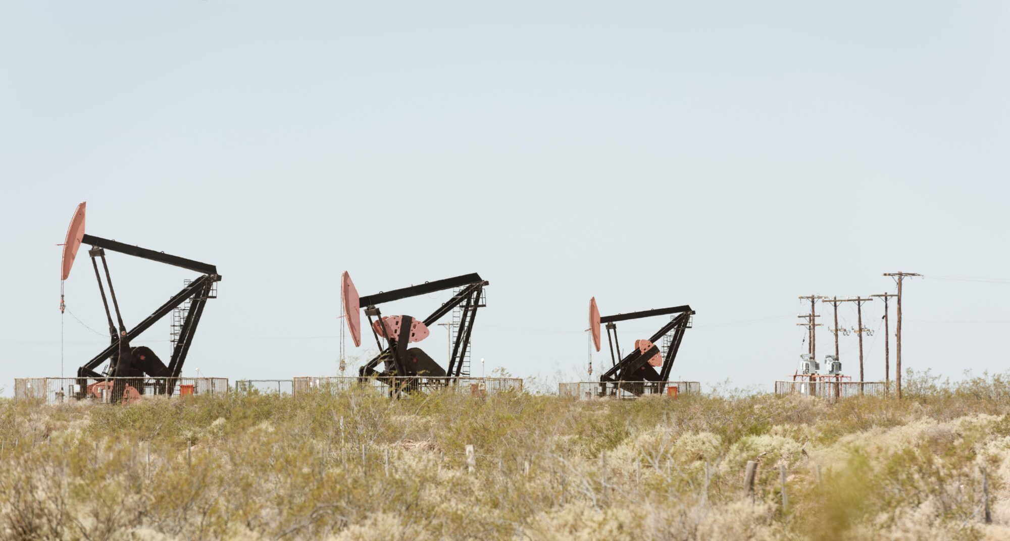 Three oil pump jacks pumping crude out of the ground in Neuquen, Argentina
