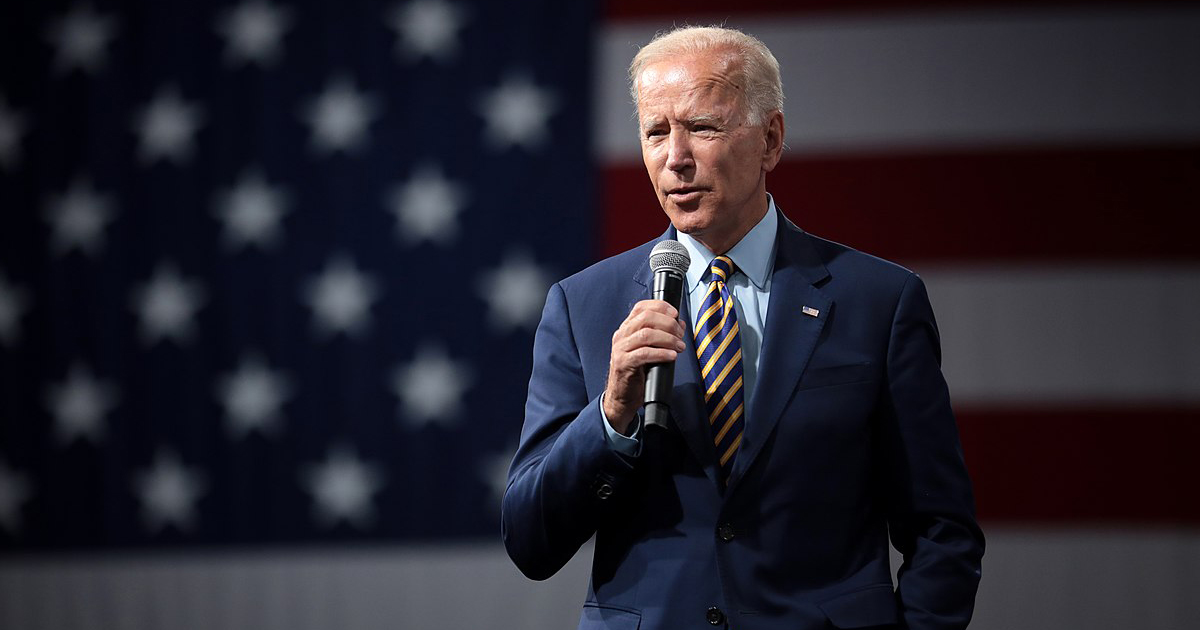 Joe Biden speaking in front of a US flag