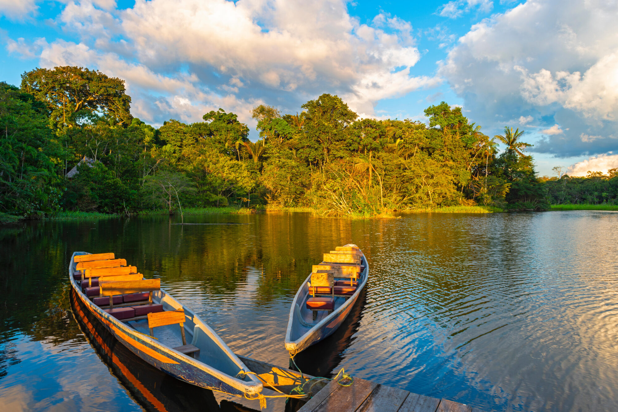 Two traditional wooden canoes at sunset in the Amazon River Basin