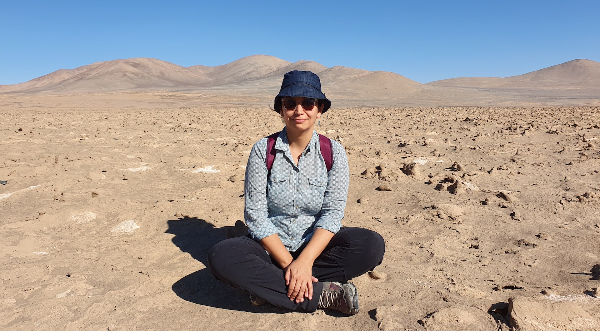 Cristina Dorador sentada em uma paisagem desértica