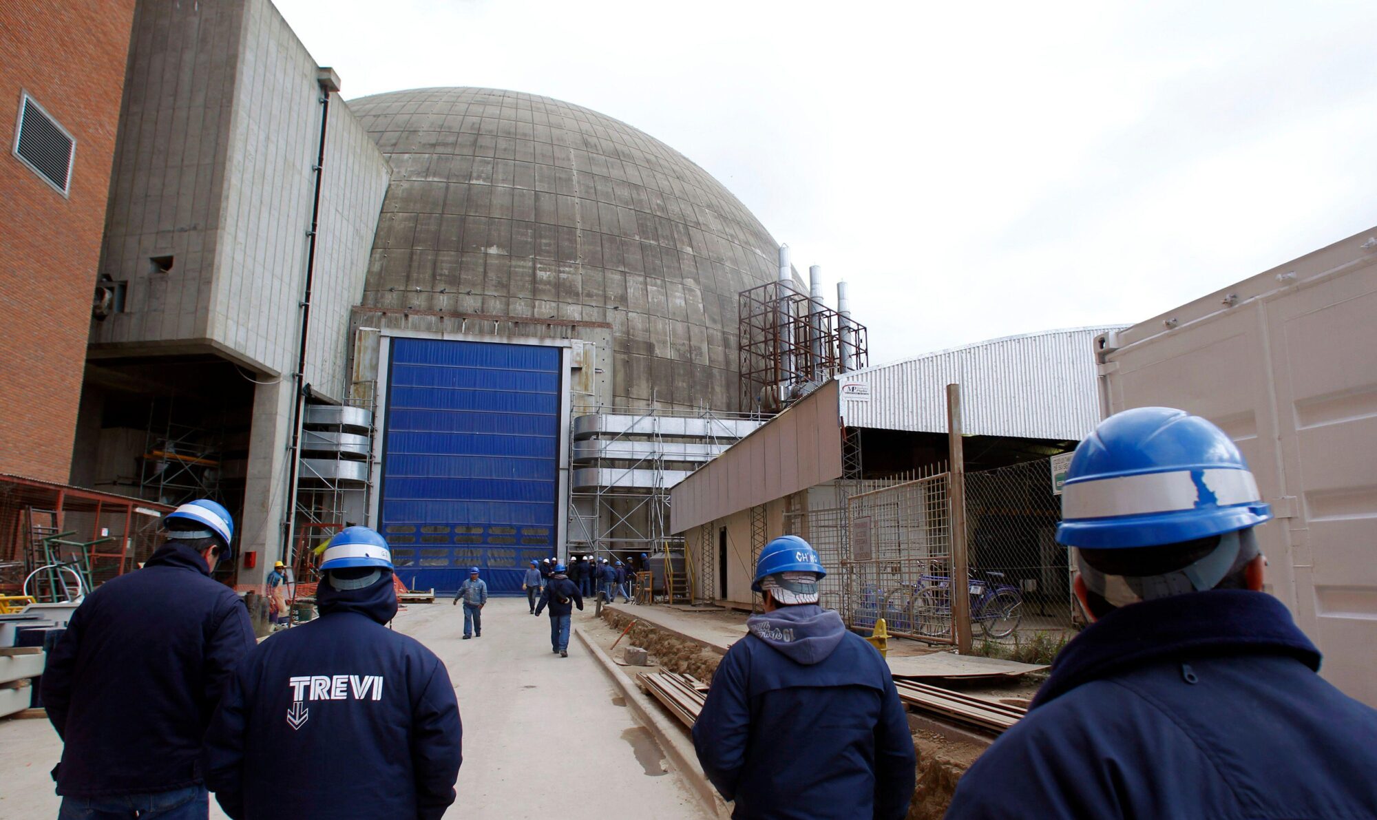 Empleados caminan hacia el reactor de la central nuclear Atucha II en Zárate, Argentina