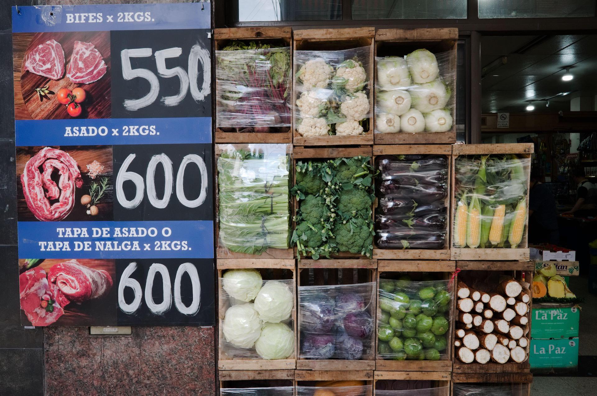 Vegetables and a poster with prices of meat