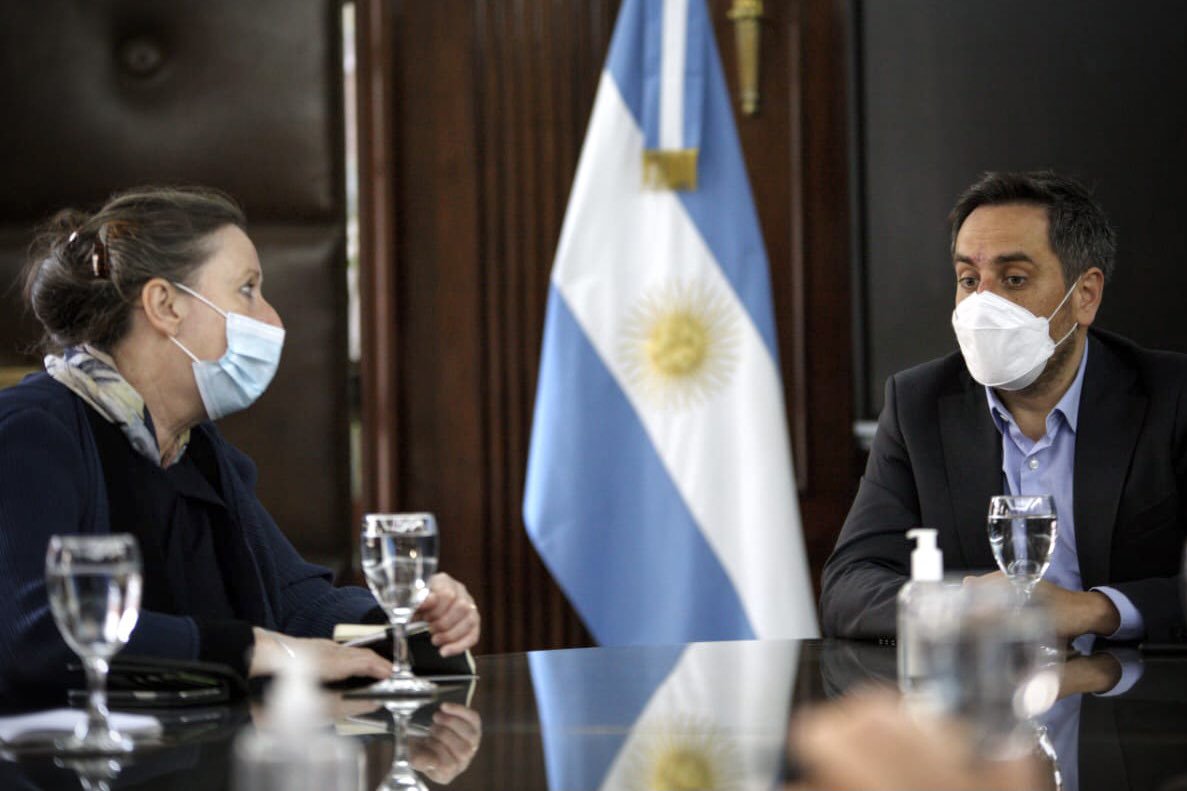 Fiona Clouder, COP26 regional ambassador, in a meeting with Juan Cabandié, Minister of Environment and Sustainable Development of Argentina, with an Argentinean flag in the background.