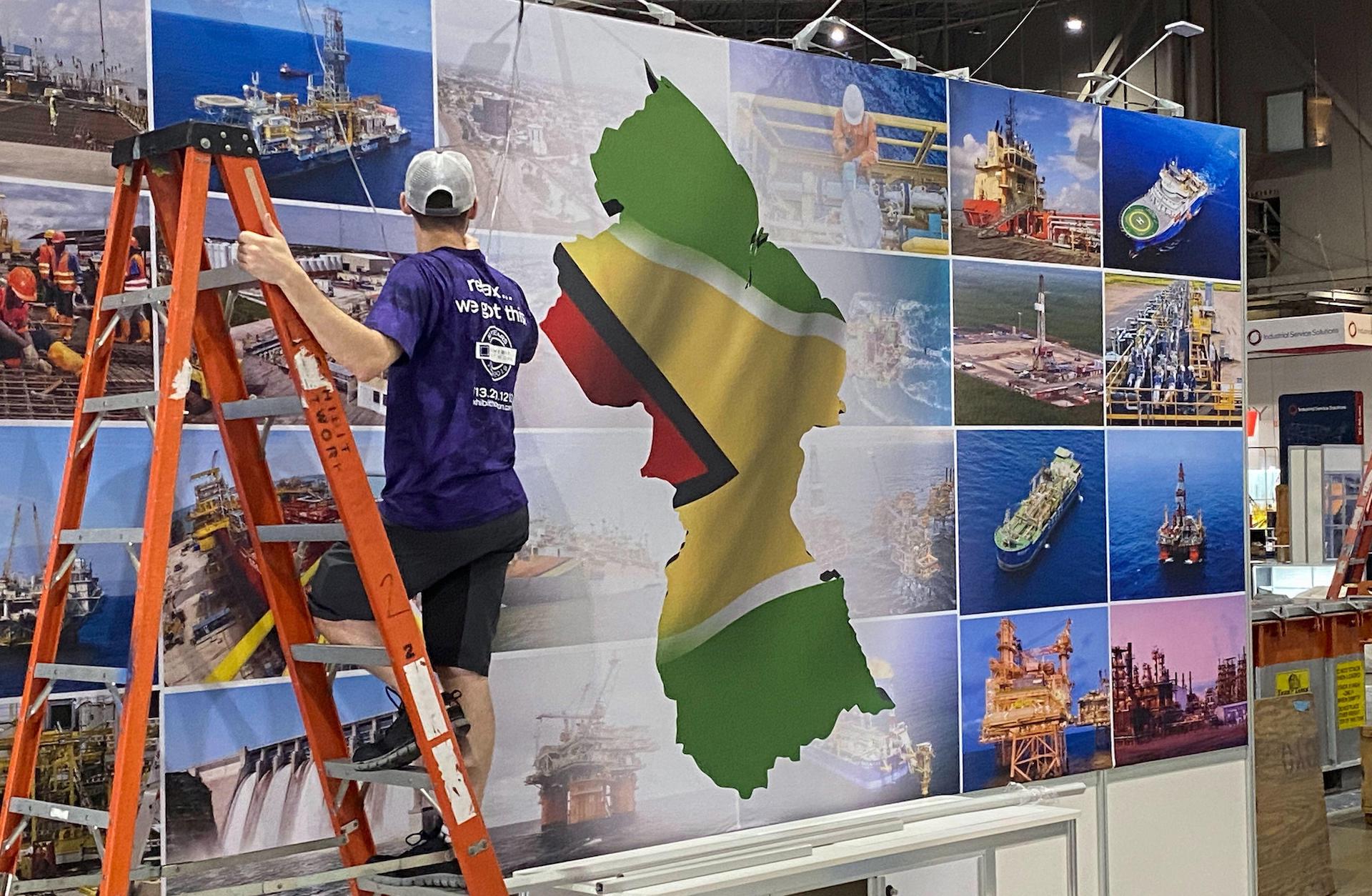 Um trabalhador monta um estande de exposição da Guiana na Offshore Technology Conference em Houston, Texas