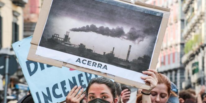 Un manifestante pide el cierre de centrales eléctricas contaminantes con un cartel