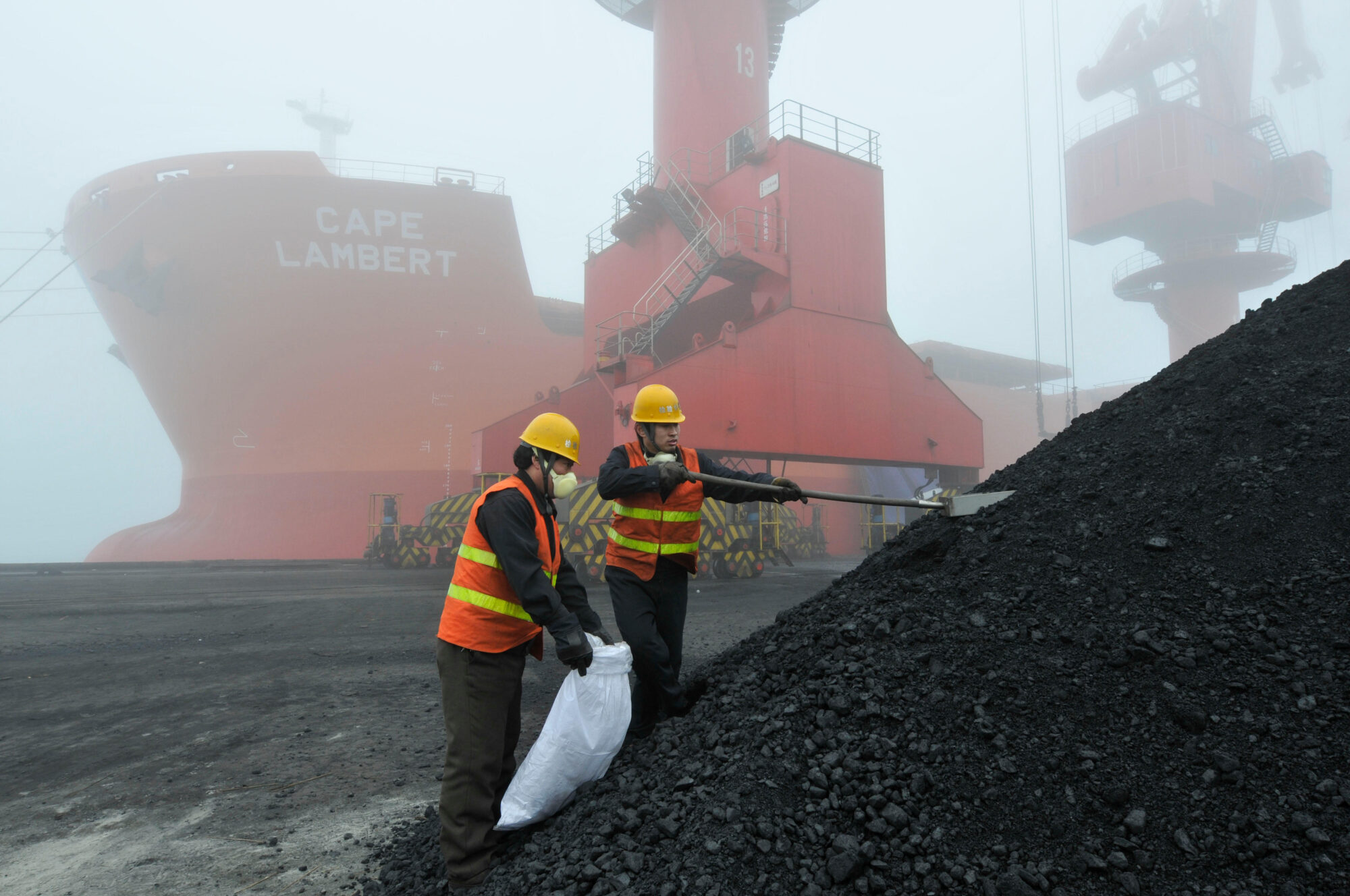 Employees inspect coal at a port