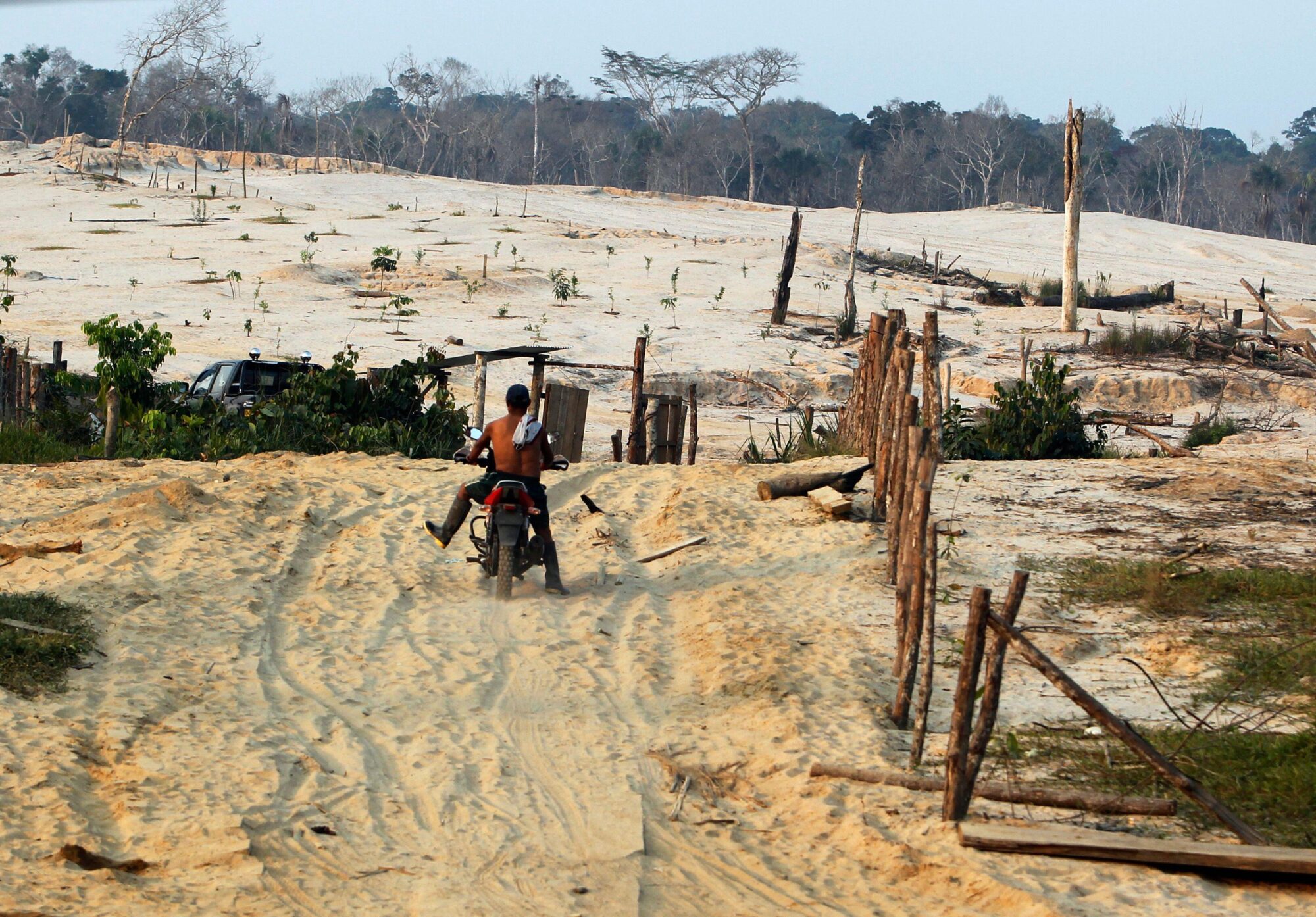 <p>A motorcyclist rides in an area deforested for informal gold mining, along a section of the Interoceanic Highway linking Peru and Brazil in the Amazon region of Madre de Dios. The road was promised to improve transit, trade and tourism but, a decade on, its record is chequered, and it has brought much change to the Peruvian Amazon. (Image: Mariana Bazo / Alamy)</p>