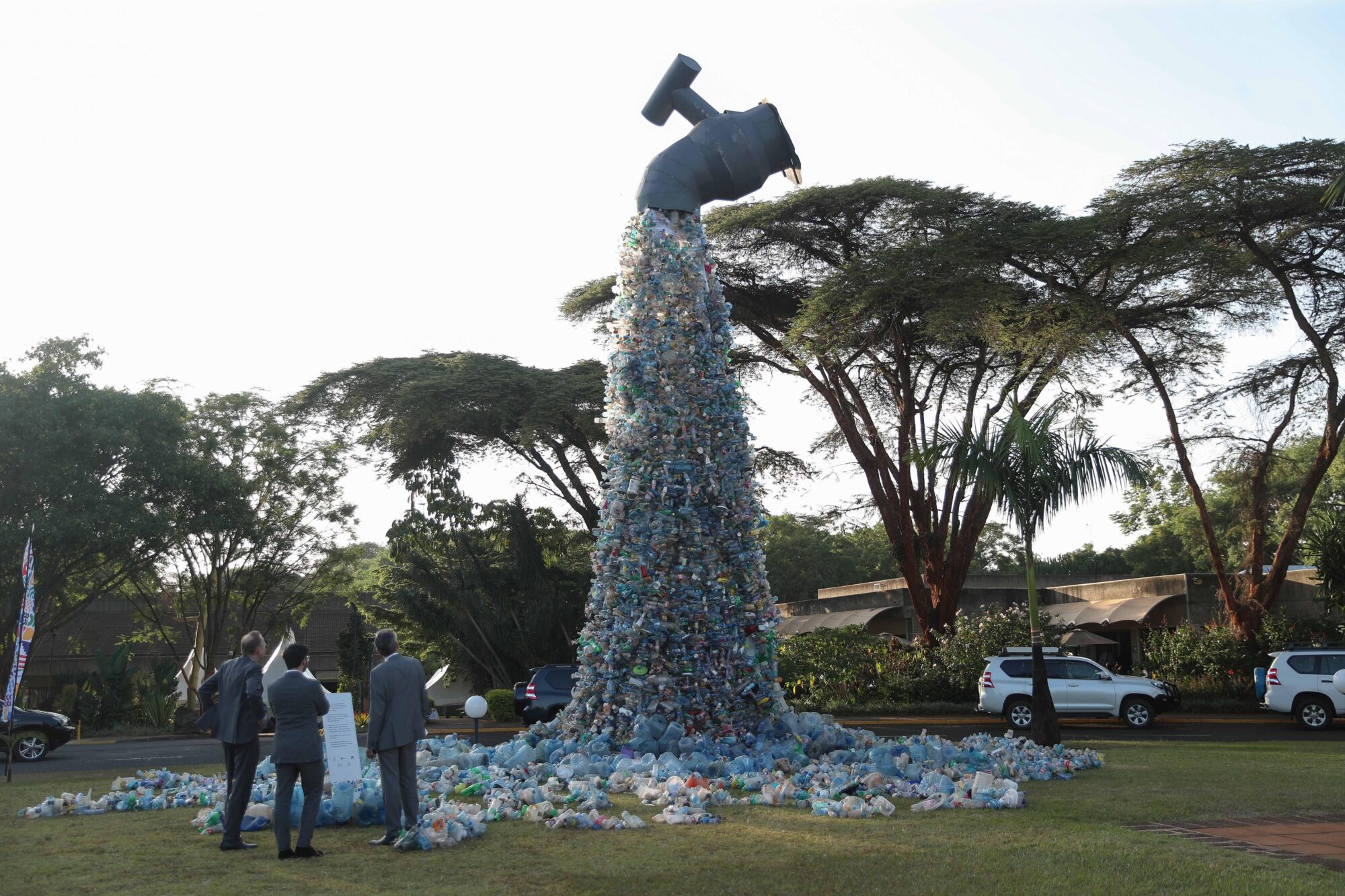 Art installation depicting plastic bottles flowing from a tap