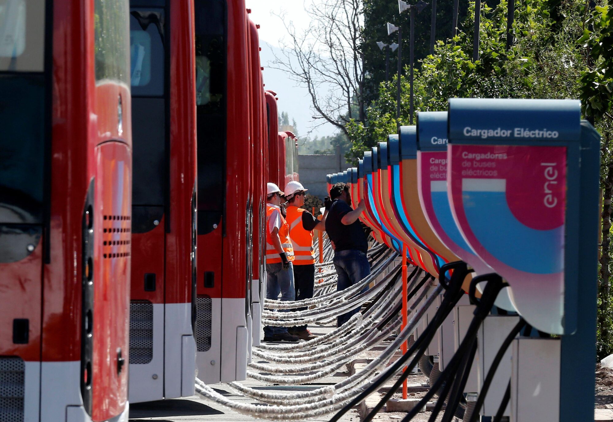 Trabajadores supervisan cargadores de autobuses eléctricos