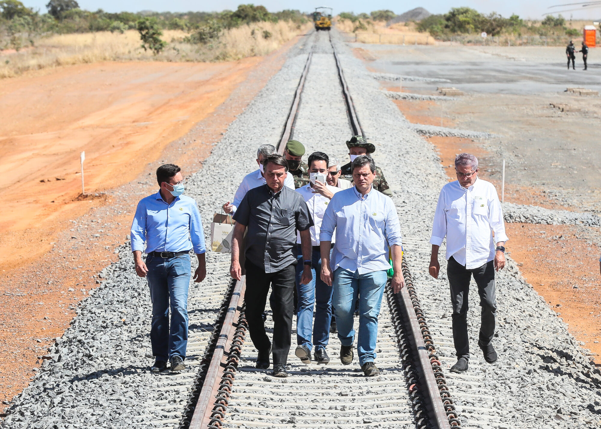 O presidente do Brasil, Bolsonaro, caminha pelos trilhos da Ferrovia de Integração Oeste-Leste (FIOL) junto com