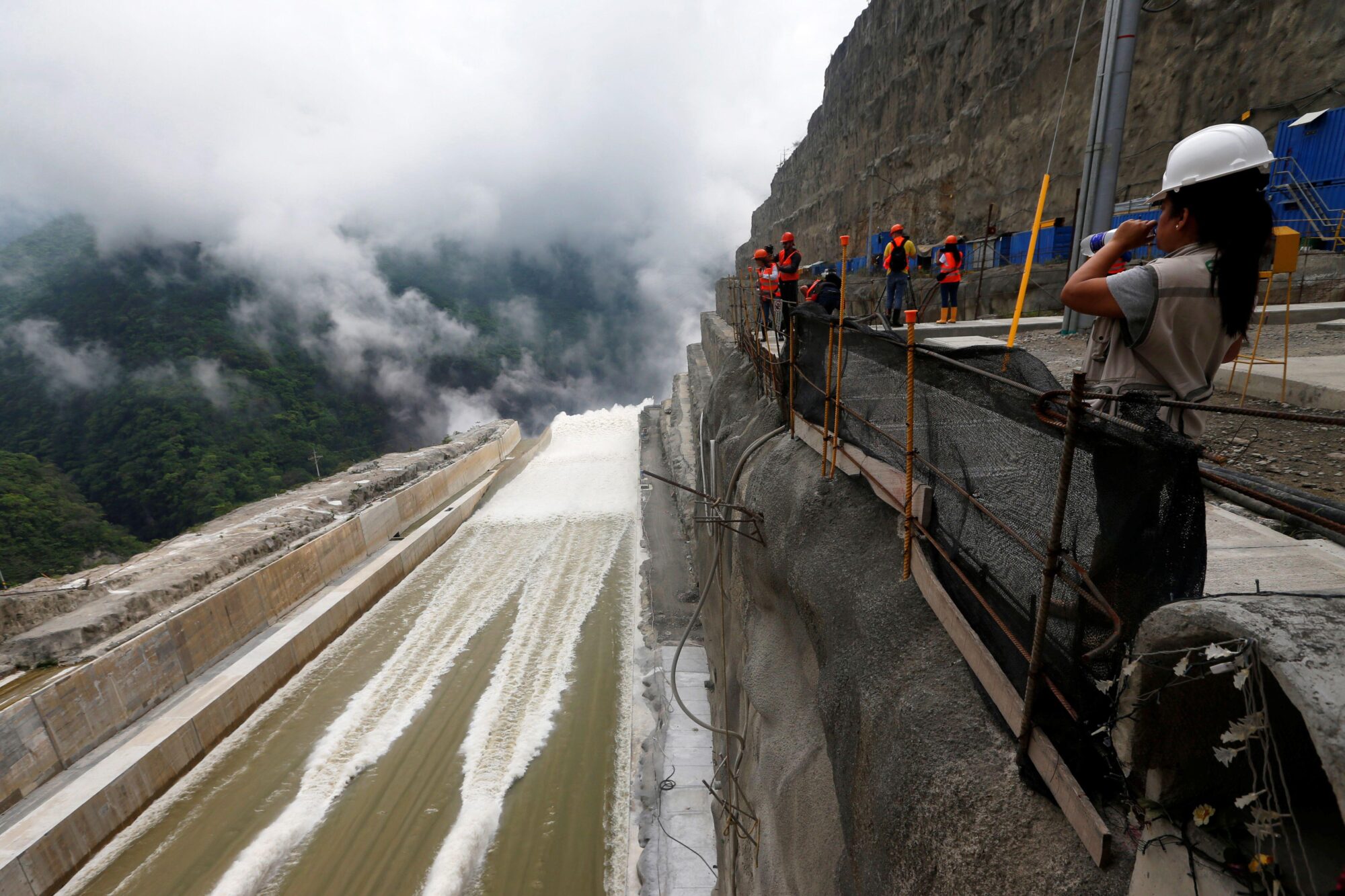 Trabalhador observa barragem de energia hidrelétrica