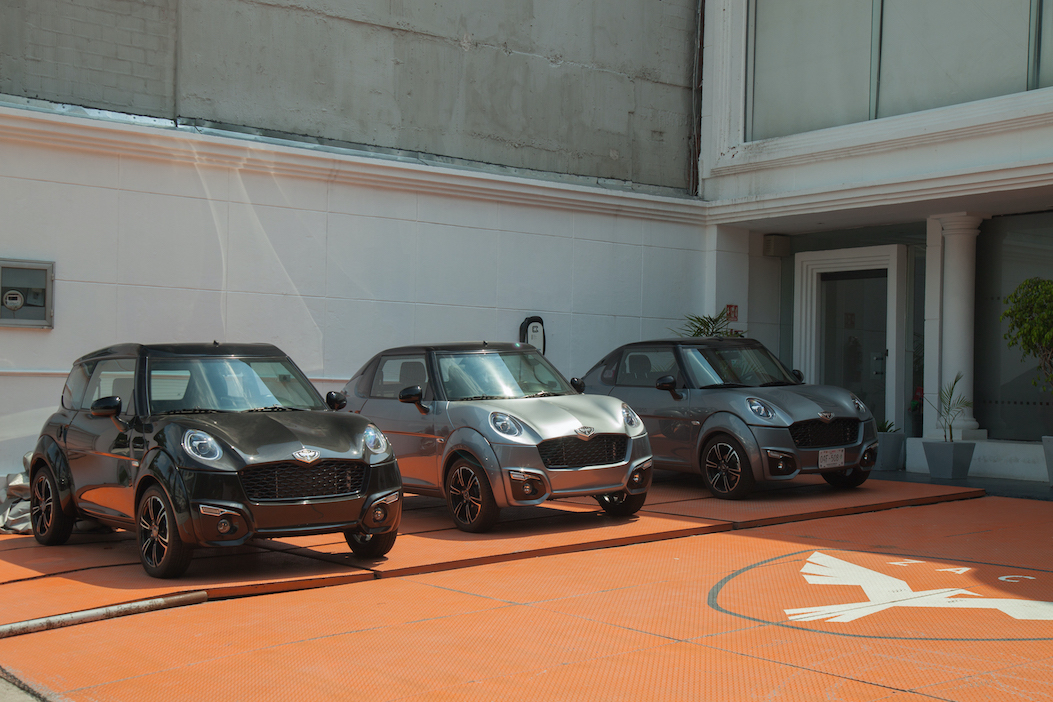 Três modelos de carros elétricos estacionados