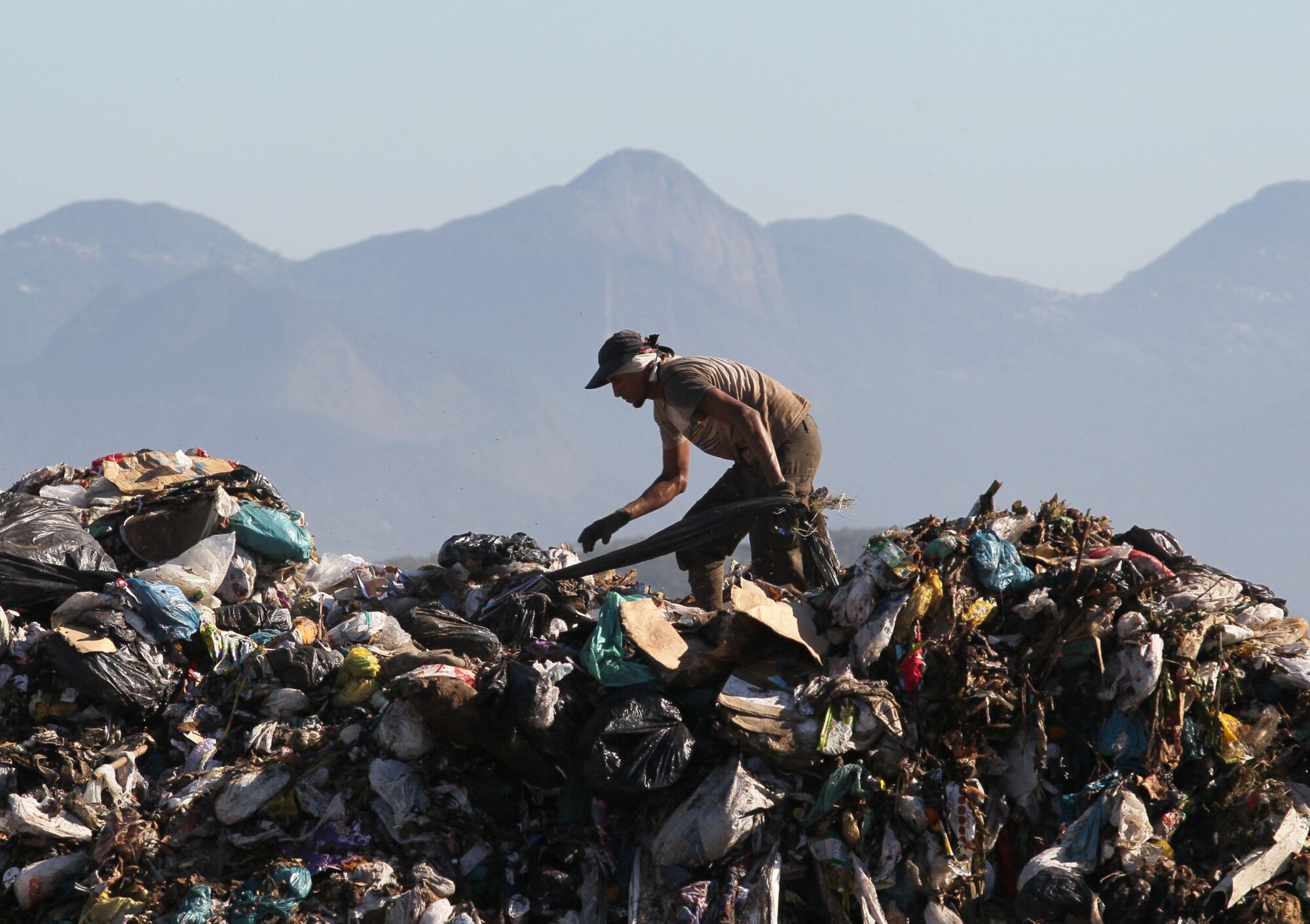 <p>Homem recolhe materiais recicláveis ​​do aterro Jardim Gramacho, no Rio de Janeiro. Marcelo Mena, ex-ministro do Meio Ambiente do Chile, diz que resíduos geram cada vez mais emissões de metano nos países do Sul Global (Imagem: Sérgio Moraes / Alamy)</p>