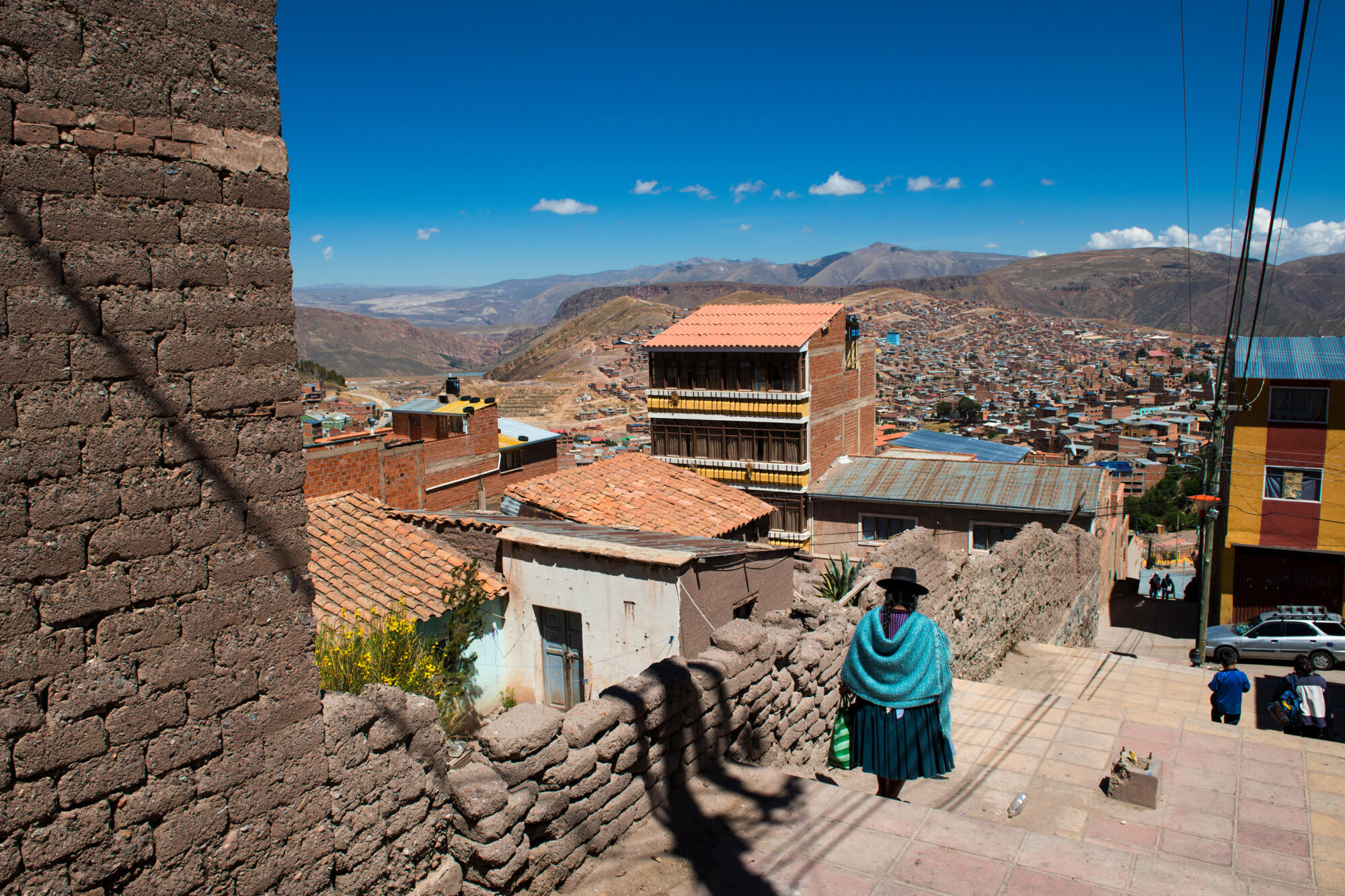 Uma mulher com trajes típicos caminha por Potosi, na Bolívia.