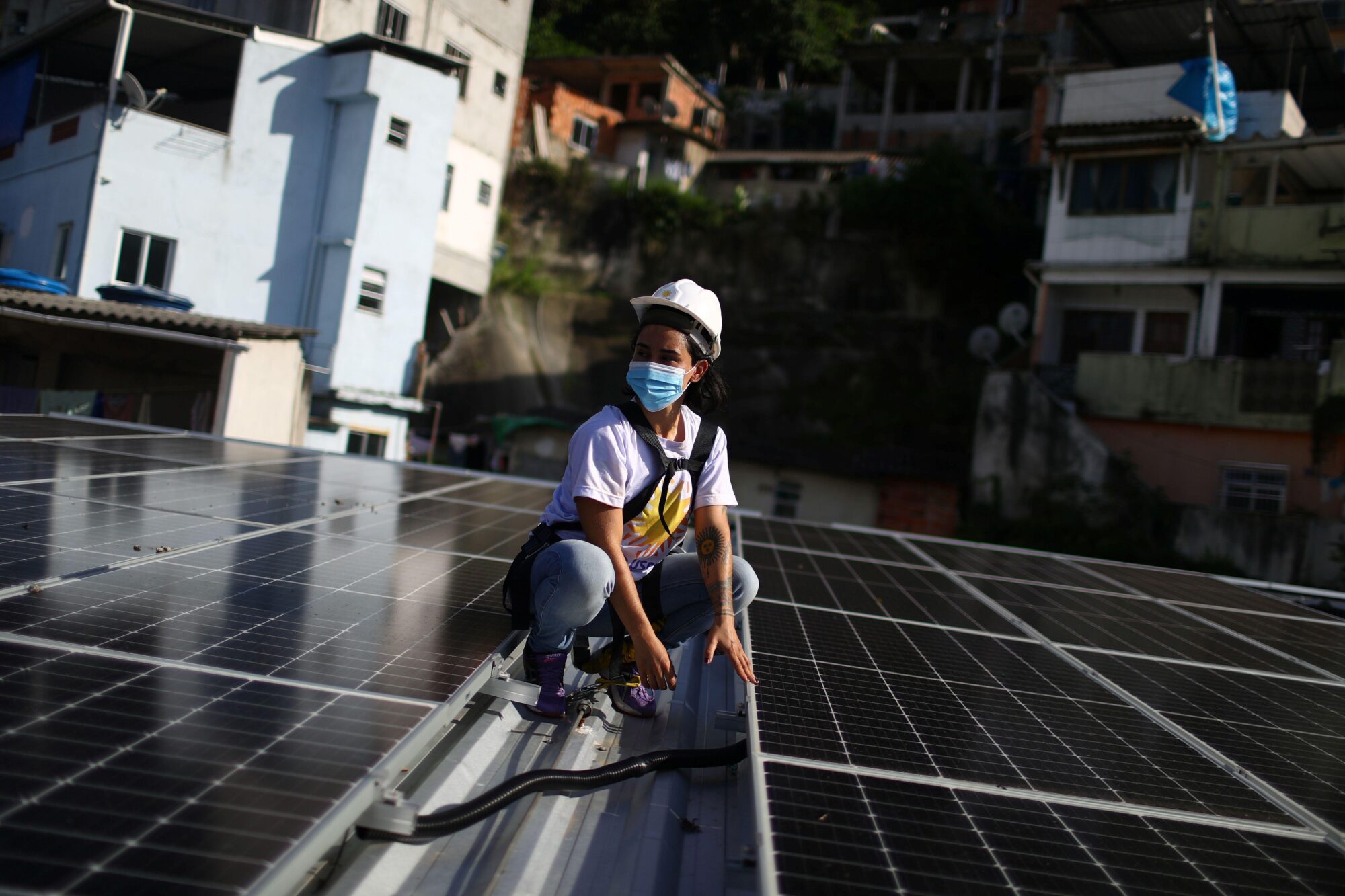 <p>Una trabajadora instala un panel solar en el asentamiento Babilonia en Río de Janeiro, Brasil. &#8220;<span style="font-weight: 400;">Cuando hablamos de pasar a la energía renovable, se trata también de construir cadenas de valor industrial y crear puestos de trabajo locales&#8221;, dijo Rana Adib. (Imagen: Pilar Olivares / Alamy)</span></p>