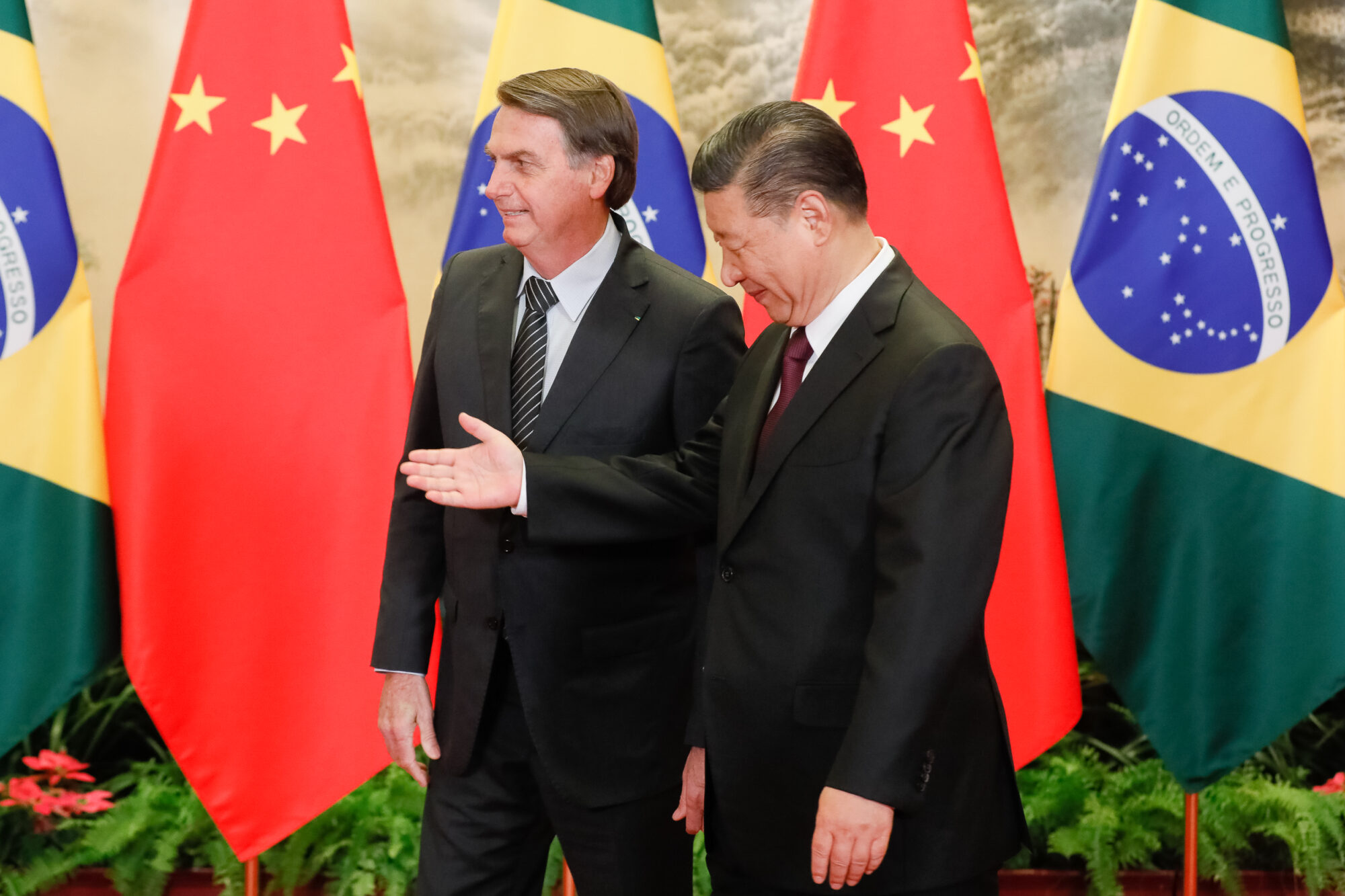 Jair Bolsonaro e Xi Jinping em frente às bandeiras da China e do Brasil