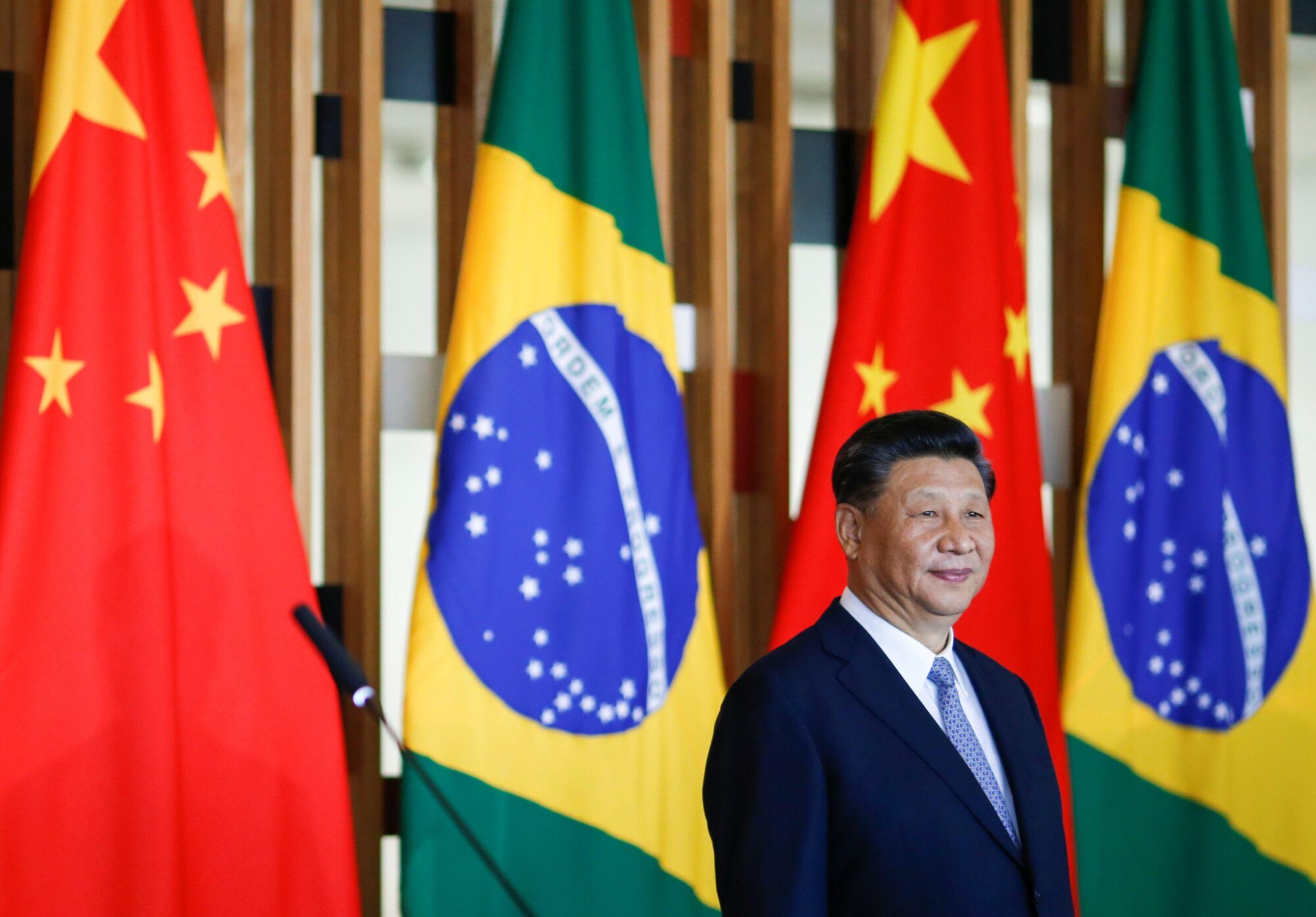 Xi Jinping em um evento em frente à bandeira brasileira