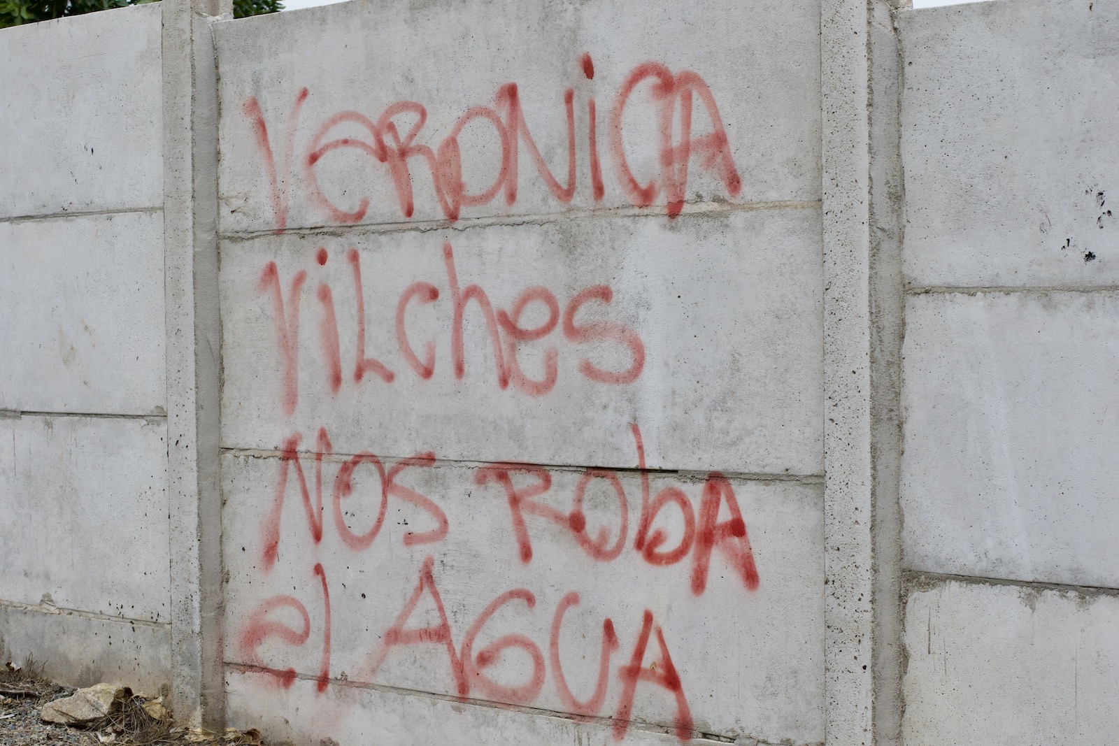 Mural saying "Veronica Vilches steals our water" in Spanish