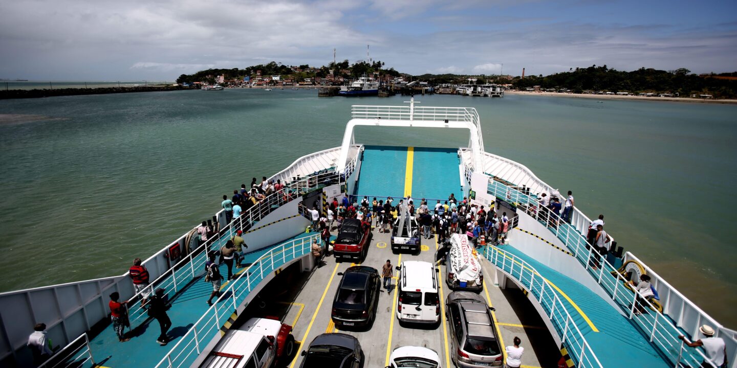 pessoas e veículos desembarcam um ferry