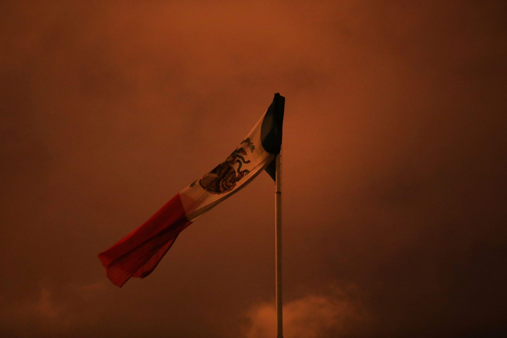 Mexican flag in a cloudy sky