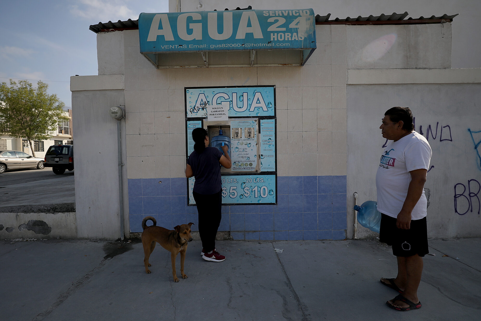 Uma mulher compra água após escassez em García, Nueva León
