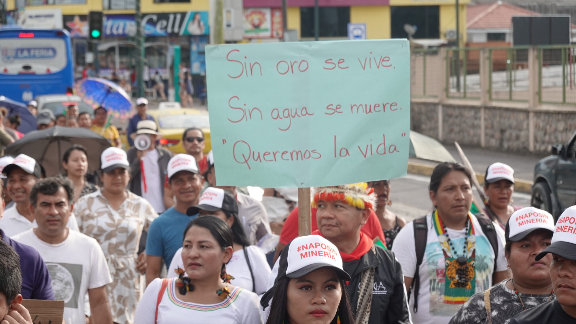 manifestantes en contra de la minería ilegal en Napo, Ecuador, con un cartel que dice "Sin oro se vive, sin agua se muere, queremos la vida"