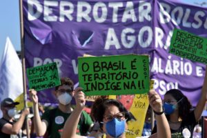 Una persona sostiene un cartel que dice "Brasil es territorio indígena" en una marcha