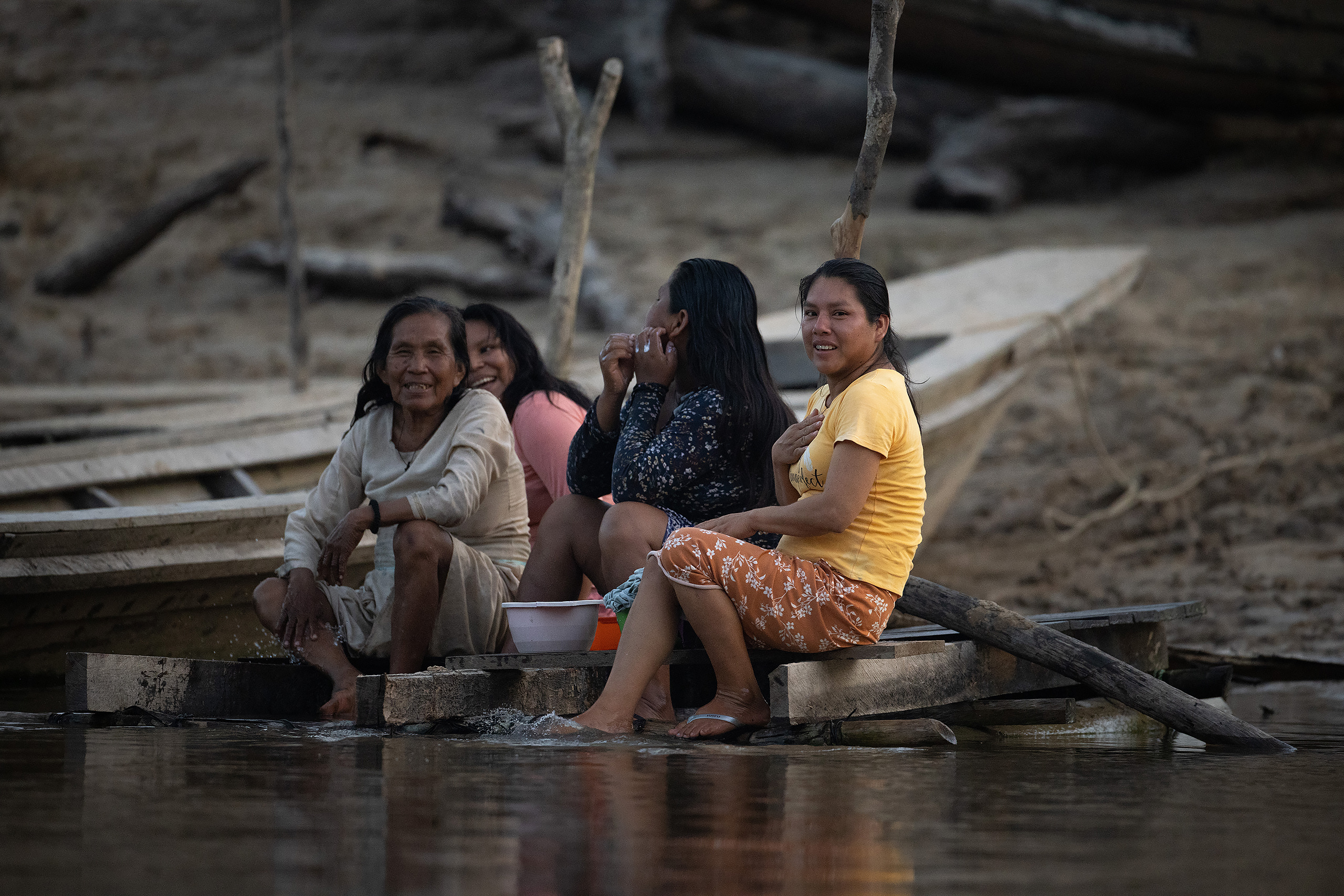 women sitting near river bank