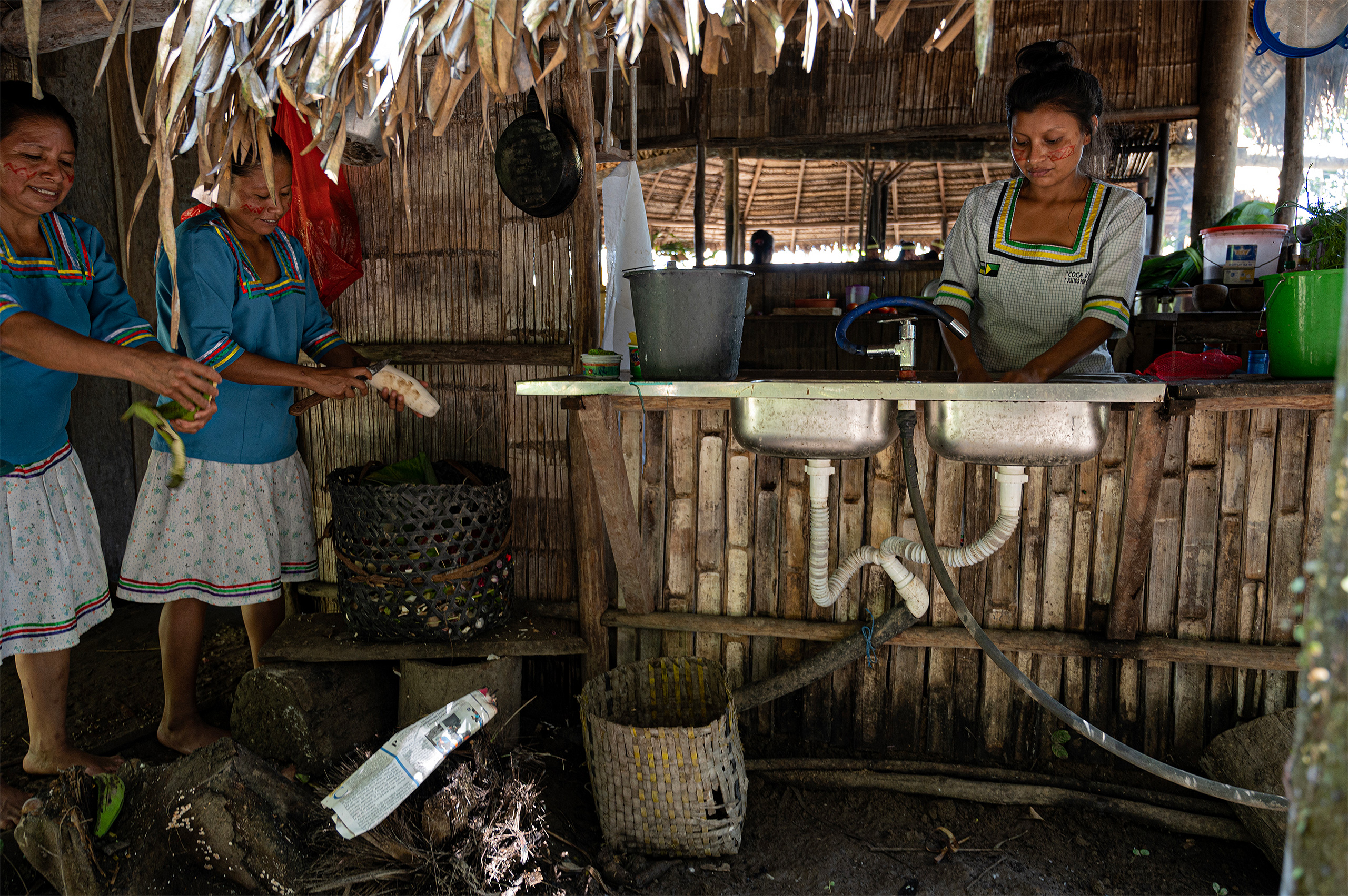 women standing in thatched roof kitchen