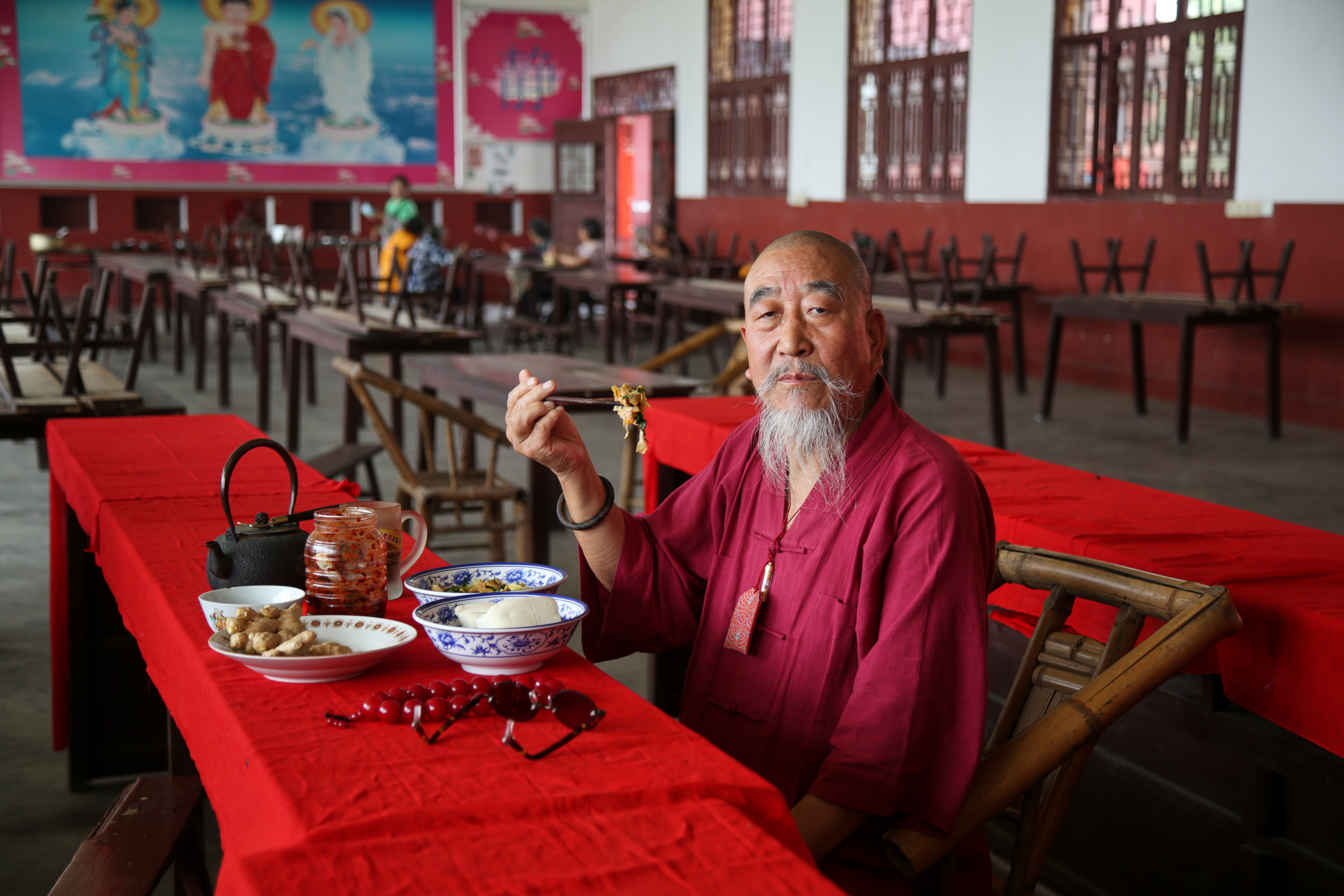 un hombre sentado frente a una mesa, comiendo
