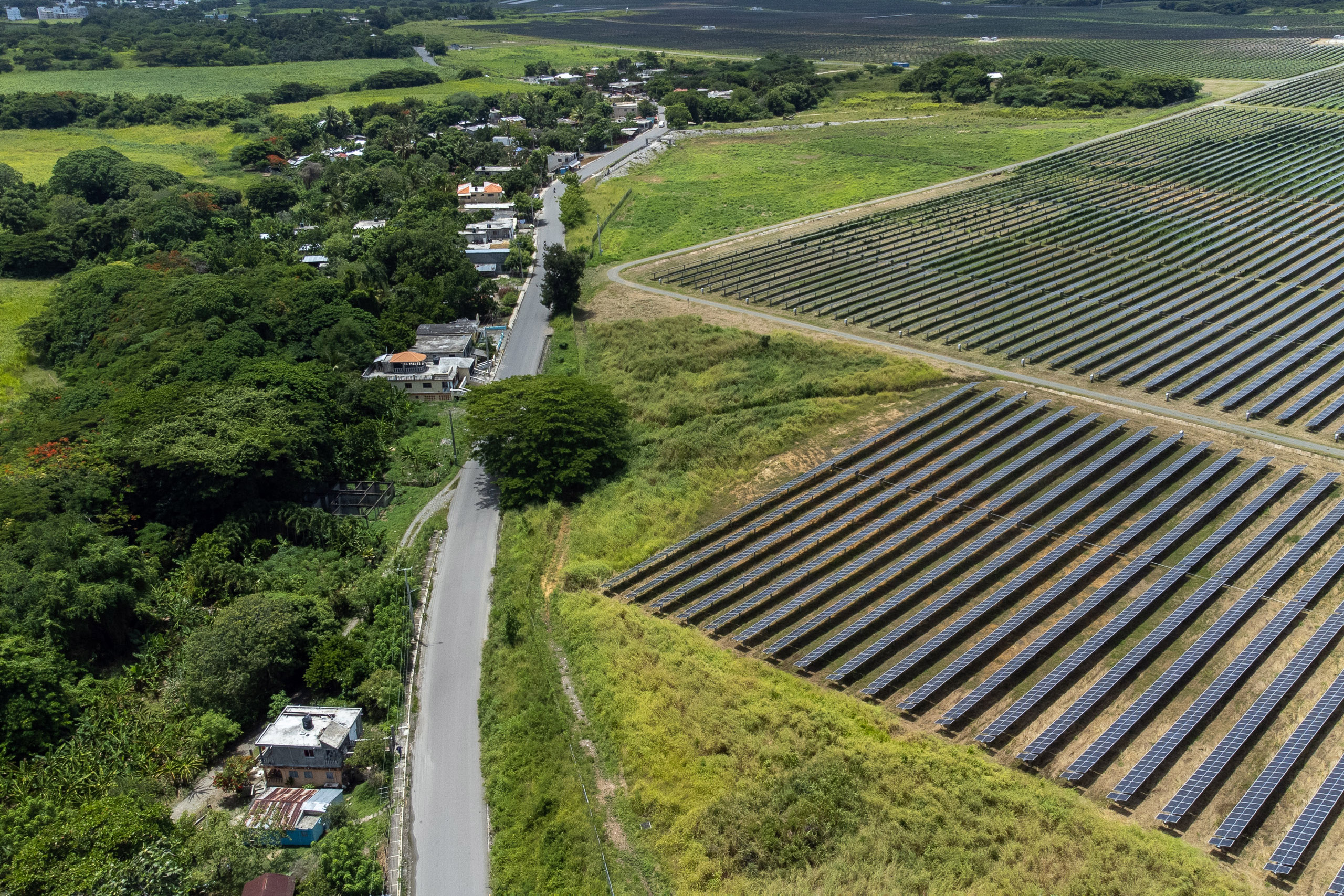 vista aérea de un campo de paneles solares cerca de una carretera