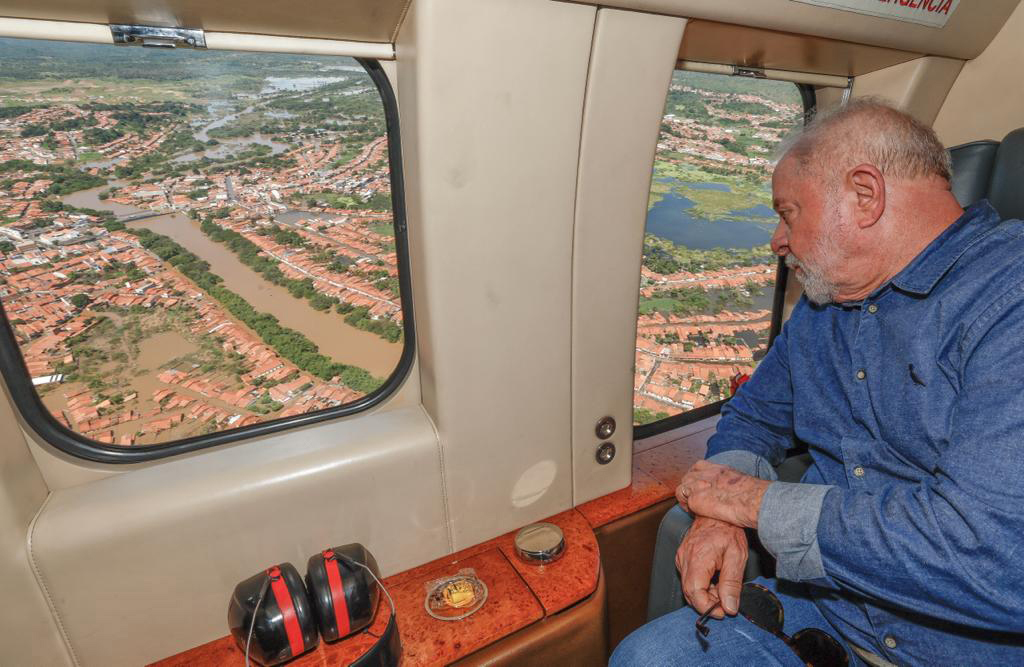 El presidente brasileño Lula mira una zona inundada por la ventanilla de un avión