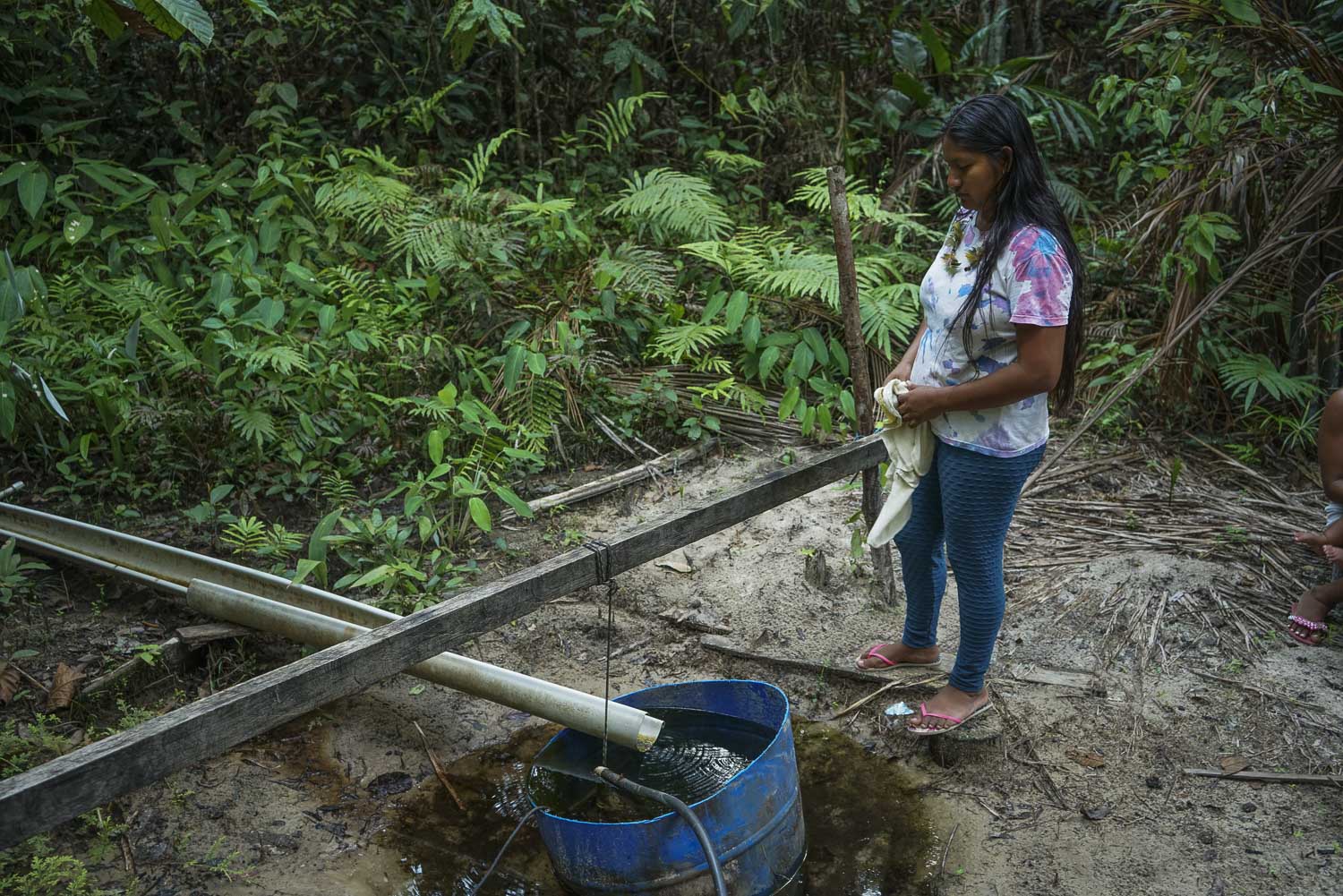 Moradora da aldeia de Branquinho, em Manaus, observa um dos únicos poços ainda com água potável nas redondezas