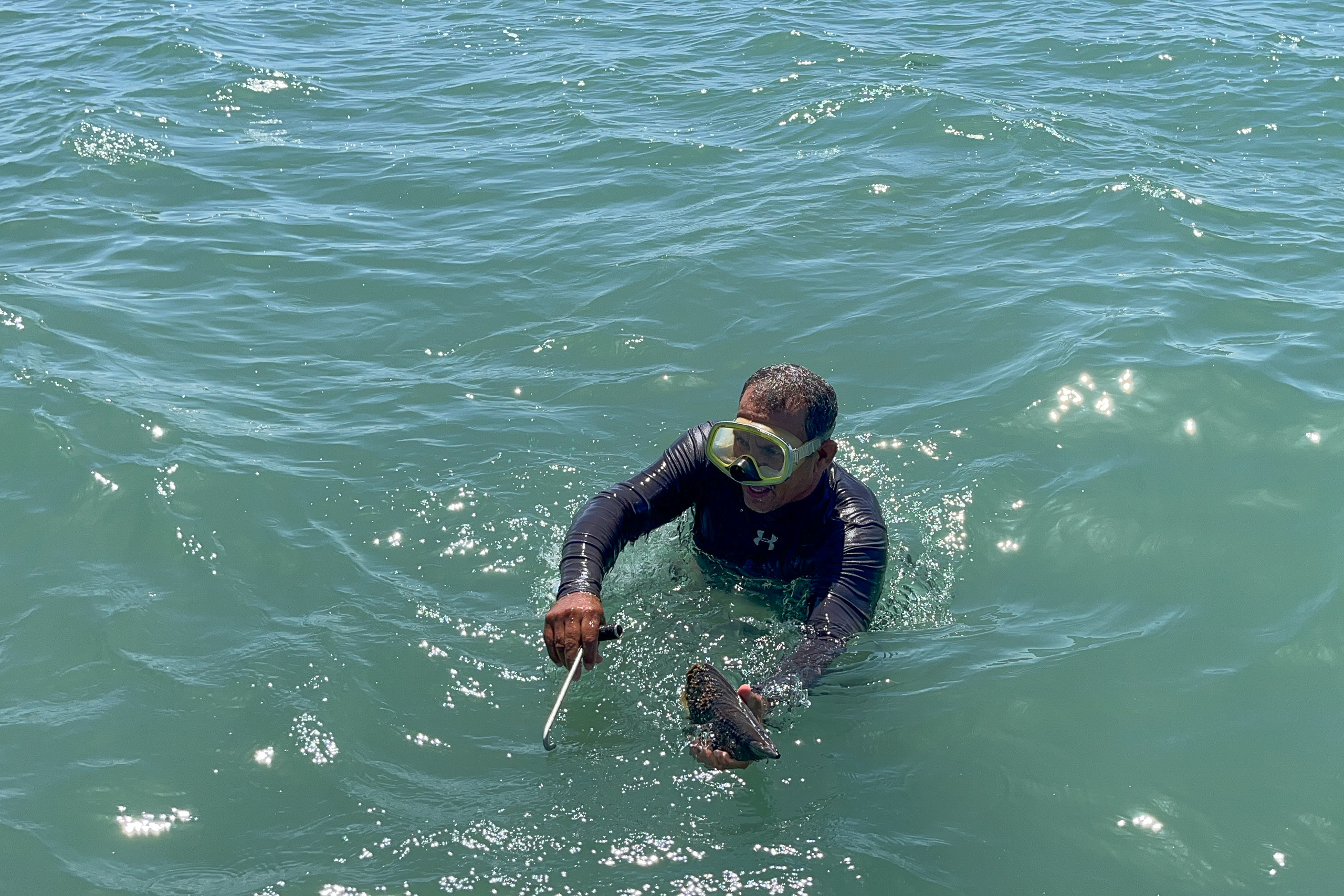 Hombre con traje de neopreno y gafas de buceo en el mar