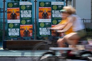 a person riding a bicycle passing by a wall of posters
