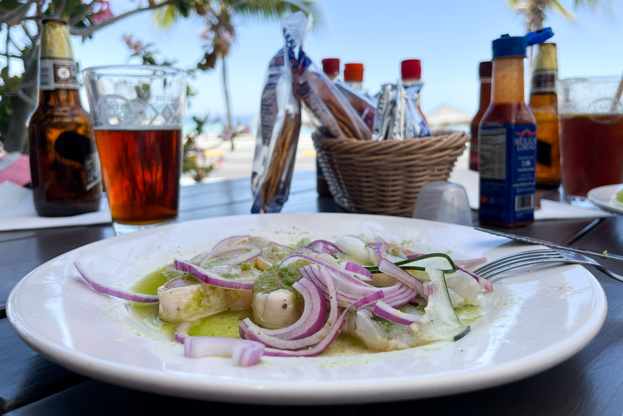 Un plato de mariscos delante de bebidas en una mesa