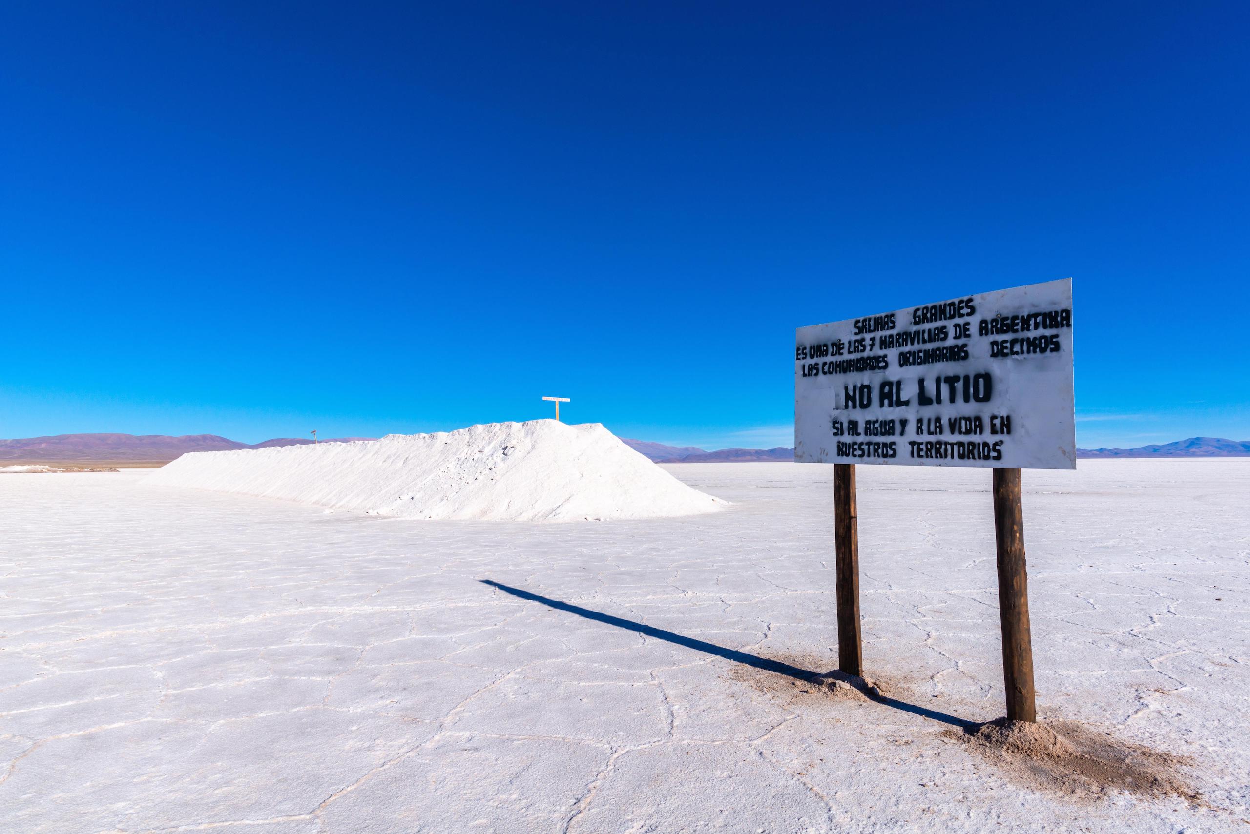 White sign in a salt flat, deep blue sky in background