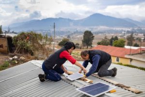 <p>Técnicos de una compañía eléctrica local sin ánimo de lucro instalan un sistema de iluminación alimentado por energía solar en una vivienda de Cantel, Guatemala. Ofrecer formación y empleo en nuevas industrias es un aspecto clave de las transiciones energéticas justas (Imagen: Jake Lyell / Alamy)</p>