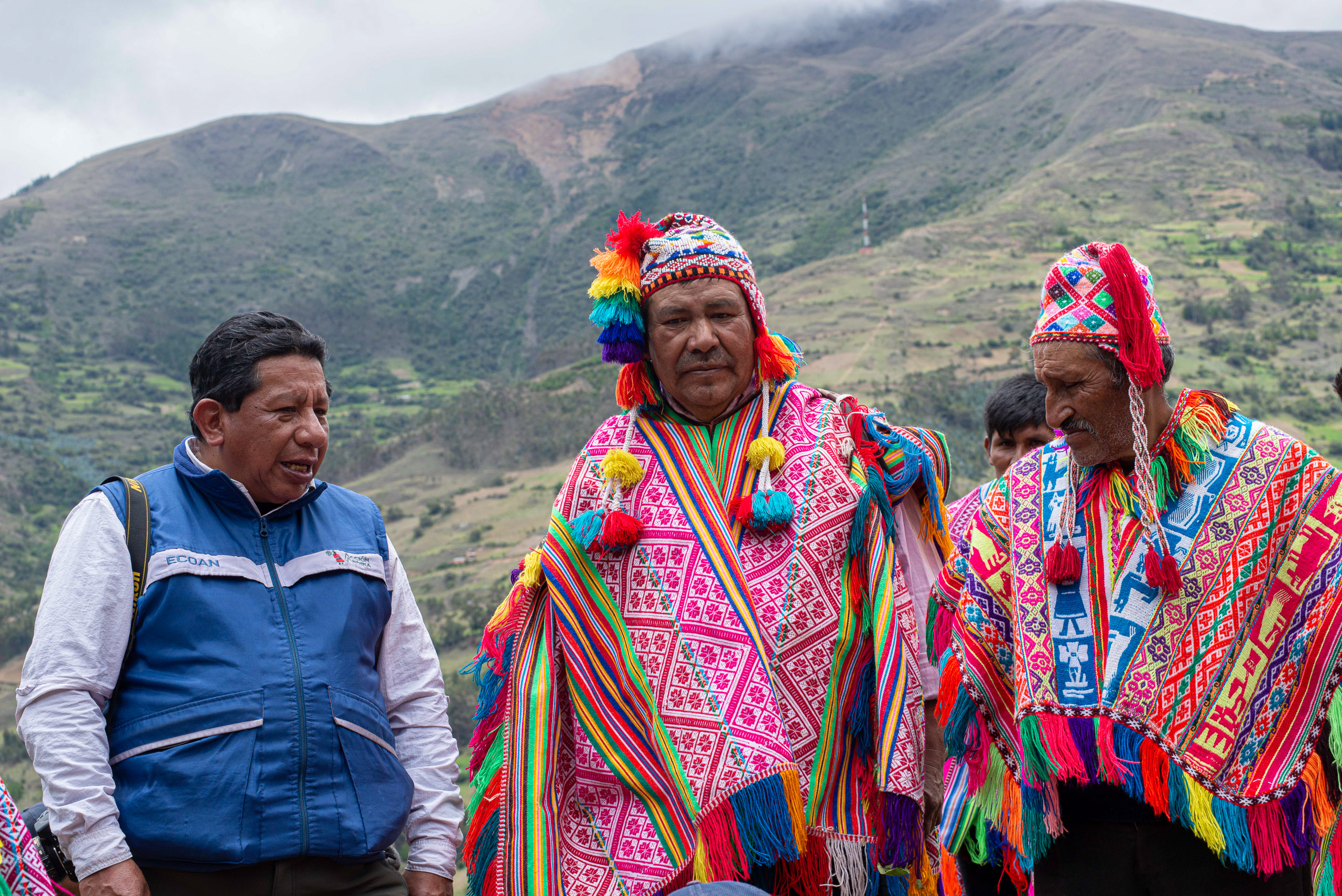 El biólogo Constantino Aucca (izquierda) junto a líderes de la comunidad de Queros parados delante de montañas